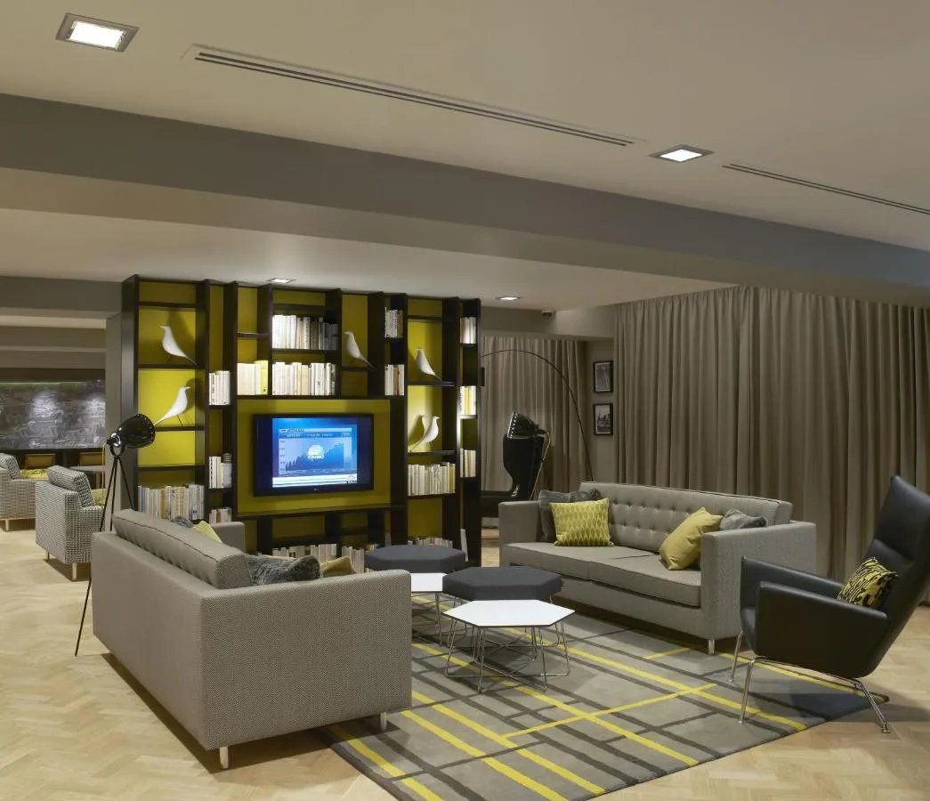 Living room with couches, TV and bookshelves at the Westminster aparthotel
