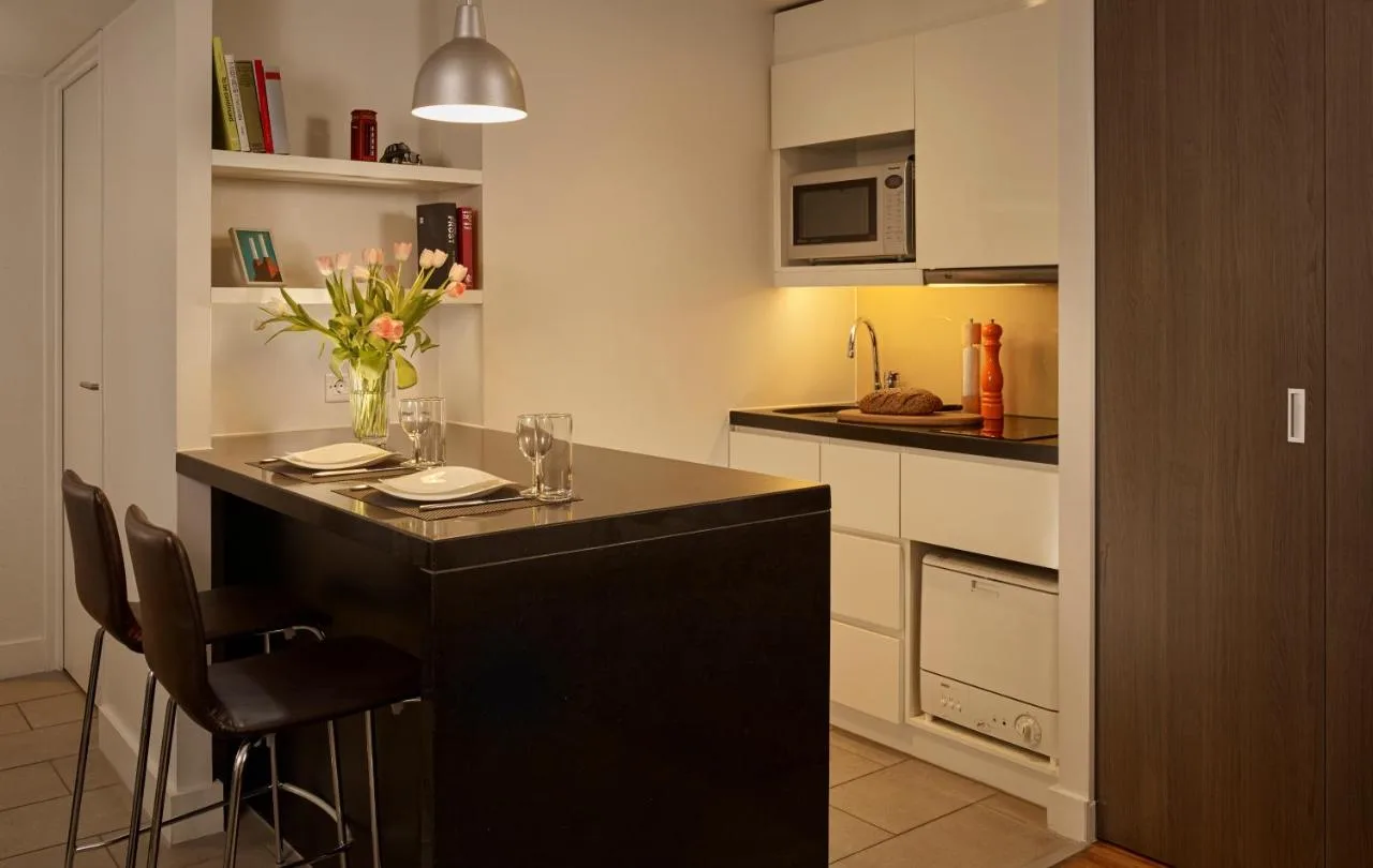 Kitchenette with black island unit in a London apartment